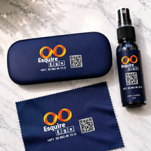 Load image into Gallery viewer, A dark navy blue Esquire ETC branded spray bottle with a black spray top, shown next to its matching hard case and microfiber cloth on a light marble surface.